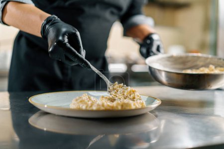 Foto de Cocina profesional en el restaurante del hotel, el chef hace buena porción de risotto - Imagen libre de derechos