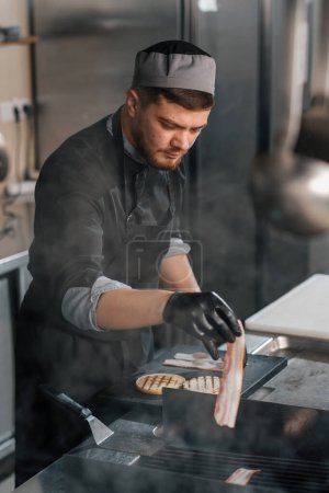 Téléchargez les photos : Cuisine professionnelle dans le chef restaurant de l'hôtel met bacon grill concept alimentaire - en image libre de droit