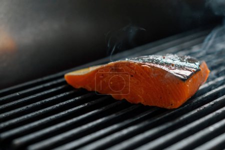 Photo for Professional kitchen in a hotel restaurant close-up of piece of fresh salmon being grilled - Royalty Free Image