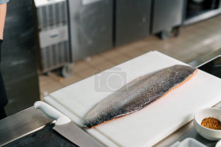 Foto de Cocina profesional en el restaurante del hotel una gran canal de salmón fresco se encuentra en la tabla de cortar - Imagen libre de derechos