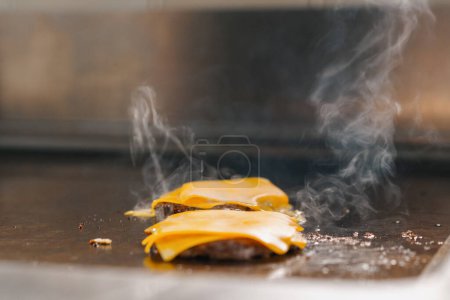 Foto de Cocina profesional hotel restaurante primer plano smash hamburguesa con queso a la plancha concepto de alimentos - Imagen libre de derechos