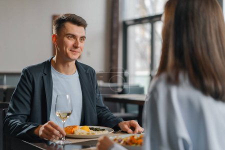 Photo for Meeting in the hotel restaurant of couple with wine and delicious dishes for lunch - Royalty Free Image