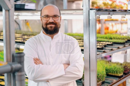 Photo for Portrait of smiling male gardener in glasses and white coat microgreen farm Healthy vegan food Organic plant germination - Royalty Free Image