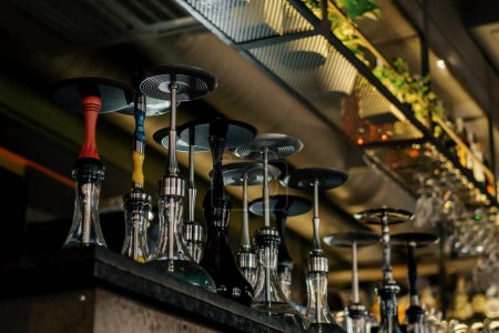 Téléchargez les photos : Divers narguilé avec équipement fumeur sur étagères salon bar flacons tuyaux bols concept de loisirs - en image libre de droit