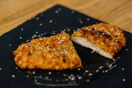 Foto de Jugoso filete de pollo caliente recién cocinado en pan rallado en un plato en el restaurante - Imagen libre de derechos