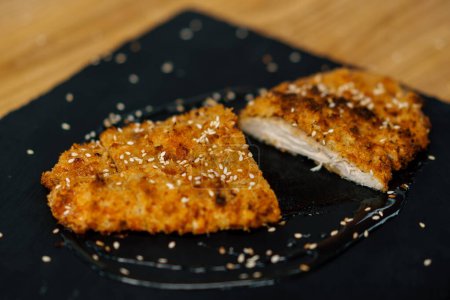 Photo for Juicy hot freshly cooked chicken fillet steak in breadcrumbs on a plate in restaurant - Royalty Free Image