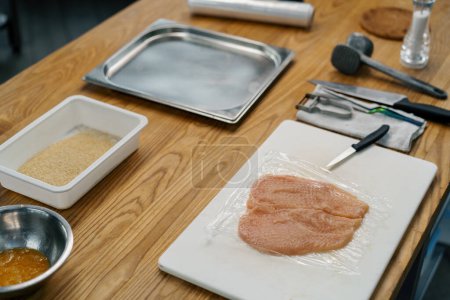 Téléchargez les photos : Chef cuisinier cuisine professionnelle martelant filet de poulet avec maillet de viande concept d'alimentation saine - en image libre de droit