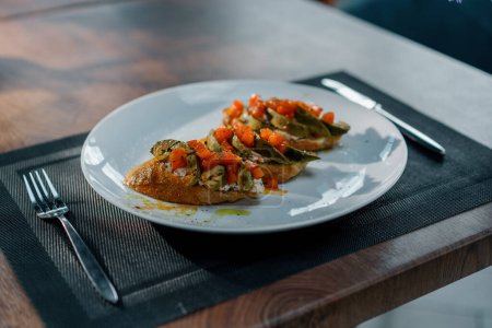 Foto de Tostadas recién hechas con aguacate asado y tomates sobre la mesa en el restaurante Concepto de alimentación saludable - Imagen libre de derechos