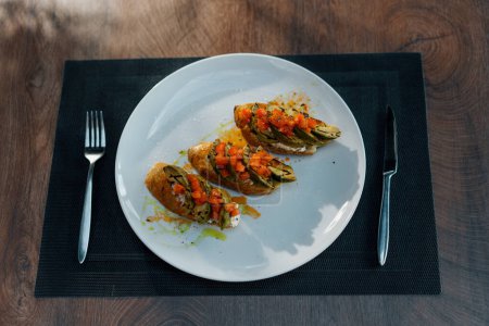 Téléchargez les photos : Pain grillé fraîchement préparé avec de l'avocat rôti et des tomates sur la table au restaurant Concept d'une alimentation saine - en image libre de droit