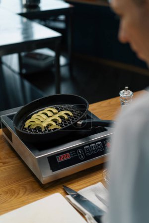 Téléchargez les photos : Chef de cuisine professionnel cuisine avocat vert frais dans la poêle à frire légumes concept d'alimentation saine - en image libre de droit