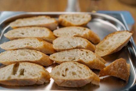 Téléchargez les photos : Cuisine professionnelle tranches fraîches de pain avec assaisonnements se trouvent sur la plaque de cuisson gros plan du plat - en image libre de droit