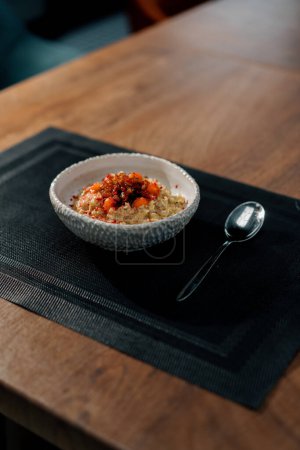 Photo for Professional kitchen freshly prepared oatmeal with caramelized fruit for breakfast in restaurant healthy food concept - Royalty Free Image