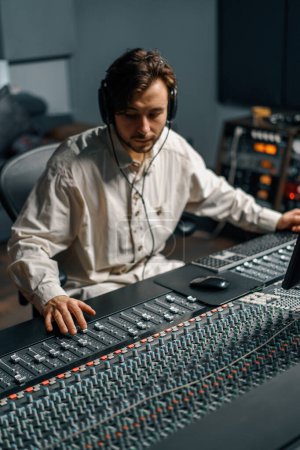 Téléchargez les photos : Ingénieur du son travaillant dans un studio de musique maison avec moniteurs et égaliseur écran mixage et mastering pistes - en image libre de droit
