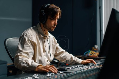 Foto de Ingeniero de sonido utiliza mezclador de audio digital Sliders Engineer presiona tecla Panel de control Técnico de estudio de grabación - Imagen libre de derechos