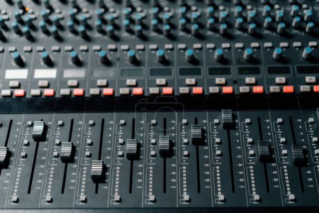 Téléchargez les photos : Un mixeur de panneau de contrôle studio d'enregistrement avec un égaliseur faders boutons pour diffuser un enregistrement de chanson - en image libre de droit