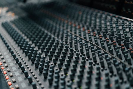 Téléchargez les photos : Un mixeur de panneau de contrôle studio d'enregistrement avec un égaliseur faders boutons pour diffuser un enregistrement de chanson - en image libre de droit