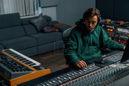 Photo for Sound engineer working in home music studio with monitors and equalizer screen mixing and mastering tracks - Royalty Free Image