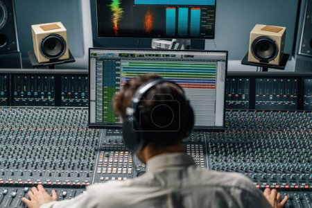 Téléchargez les photos : Ingénieur du son travaillant dans un studio de musique avec moniteurs et égaliseur écran mixage et mastering pistes - en image libre de droit