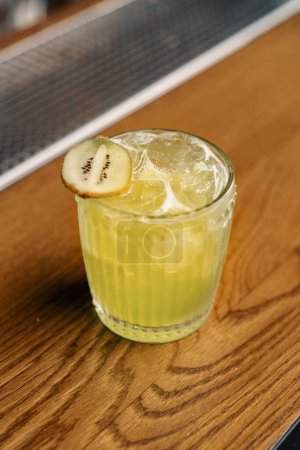 Foto de Primer plano del delicioso cóctel alcohólico preparado Apple Smash con kiwi en el bar y espera al huésped - Imagen libre de derechos