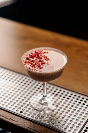 Téléchargez les photos : Délicieux cocktail club de bleuets rose fraîchement préparé avec des framboises se tient sur le bar en attendant les invités - en image libre de droit