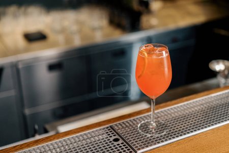 Photo for Delicious Aperol spritz cocktail standing on bar counter in restaurant bar waiting waiter and customer - Royalty Free Image