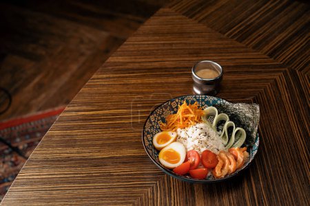 Foto de Delicioso tazón de salmón con verduras y arroz cubierto de salsa en restaurante oriental Comida asiática saludable - Imagen libre de derechos