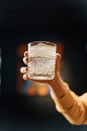 Téléchargez les photos : Client tenant délicieux cocktail de jardin de gin fraîchement fait avec concombre dans bar à main boissons concept - en image libre de droit