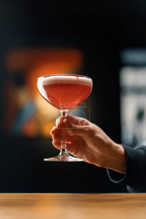 Téléchargez les photos : Client tenant délicieux rose fraîchement fait framboise cocktail punch au lait dans bar à main boissons concept - en image libre de droit