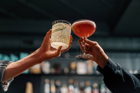 Téléchargez les photos : Proche de deux personnes acclamant des cocktails dans un bar ou un club discothèque concept boissons et cocktails - en image libre de droit