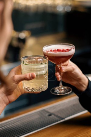 Photo for Close up of two people cheering cocktails in bar or disco club drinks and cocktails concept - Royalty Free Image
