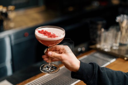 Téléchargez les photos : Le client prend un délicieux cocktail de punch au lait de framboise rose fraîchement préparé au bar - en image libre de droit