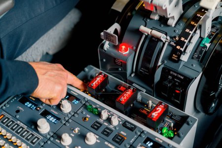 Photo for The captain presses the buttons on the control panel to start the engine of plane flight Up close flight simulator - Royalty Free Image