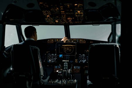 Téléchargez les photos : Pilote d'avion professionnel ajuste les paramètres de vol de l'avion en vol à haute altitude Vue de l'intérieur de la cabine - en image libre de droit