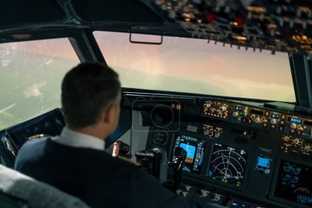 Téléchargez les photos : Le pilote dans le poste de pilotage de l'aéronef turbulence pendant le vol Dispositifs de navigation sur simulateur de vol - en image libre de droit
