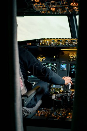 Foto de Piloto que presiona el pedal de gas en la cabina del avión de reacción durante un entrenamiento de vuelo o simulador de vuelo - Imagen libre de derechos
