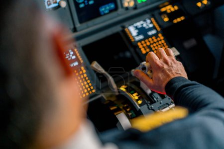 Téléchargez les photos : Gros plan de la main d'un pilote pressant la manette des gaz dans le poste de pilotage d'un avion à réaction réduisant la puissance du moteur - en image libre de droit