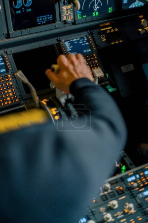 Foto de Primer plano de la mano de un piloto presionando el acelerador en la cabina del avión jet reduciendo la potencia del motor - Imagen libre de derechos