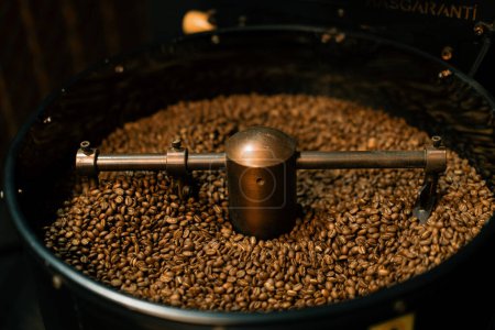 Foto de La producción de café es el proceso de tostado de granos de café frescos granos de café mezclados y enfriados de cerca - Imagen libre de derechos