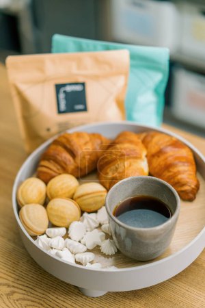 Téléchargez les photos : Délicieux croissants meringués frais et noix avec lait condensé et café sur une table dans un café - en image libre de droit