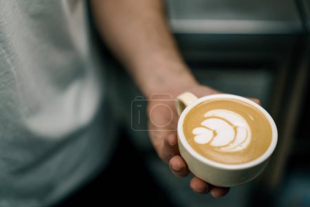 Foto de Barista sirviendo un café latte caliente del cliente en una taza de café en el camarero de la cafetería que prepara café caliente con leche - Imagen libre de derechos