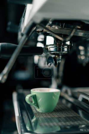 Photo for Pouring coffee flows from the machine into the cup making hot drink using filter holder freshly ground coffee flows - Royalty Free Image