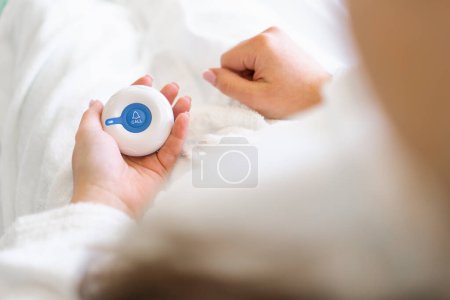 Foto de Un dedo presionando el botón de llamada de emergencia en una clínica médica un paciente llama a una enfermera para pedir ayuda en la sala del hospital - Imagen libre de derechos