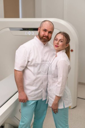 Foto de Médicos sonrientes y satisfechos en uniforme posando cerca de la resonancia magnética imagen concepto de la máquina profesiones y medicina - Imagen libre de derechos
