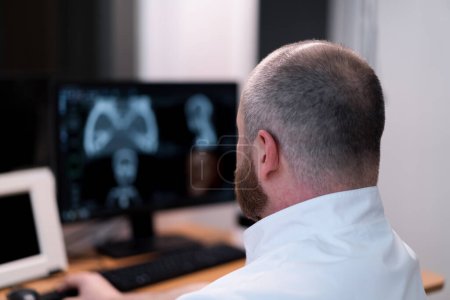 Photo for The patient undergoes computed tomography in the clinic the radiologist monitors the procedure and the results of scan - Royalty Free Image