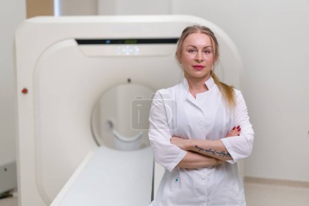 Téléchargez les photos : Grave belle femme médecin CT radiologue dans le bureau de tomodensitométrie attendre les patients avant de commencer le travail - en image libre de droit