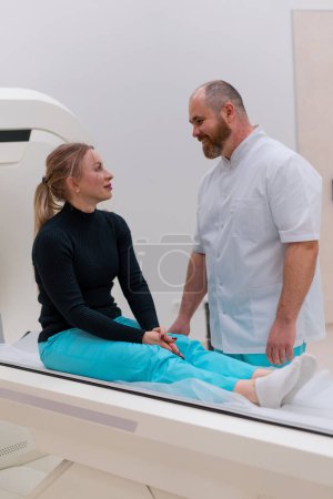 Téléchargez les photos : Un médecin consulte un patient dans une clinique médicale avant la procédure de tomodensitométrie aux rayons X - en image libre de droit