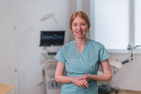 Téléchargez les photos : Médecin gynécologue souriant dans le bureau gynécologique près de l'échographie et chaise gynécologique attendant les patients - en image libre de droit