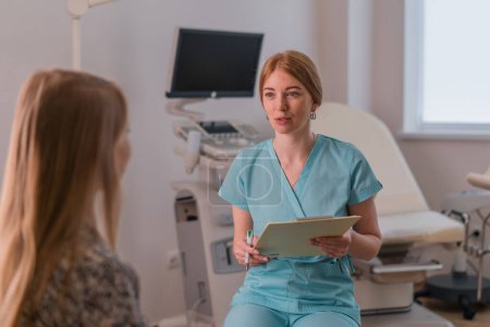 Téléchargez les photos : Un gynécologue parle à un patient lors d'une consultation médicale dans une clinique moderne dans un cabinet gynécologique - en image libre de droit