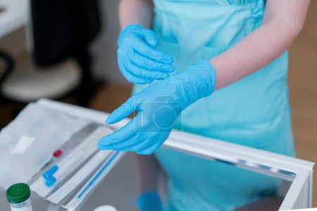 Téléchargez les photos : Un gynécologue portant des gants en caoutchouc se prépare à examiner un patient en clinique de gynécologie gros plan - en image libre de droit