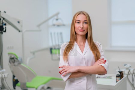 Photo for Portrait of beautiful young smiling doctor dentist standing in the dental office before the procedure - Royalty Free Image